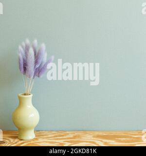 Vase aus lila Hasen Schwanz Gras trockene Blumen auf Holztisch. Minze Wand Hintergrund. Kopieren Raum Stockfoto