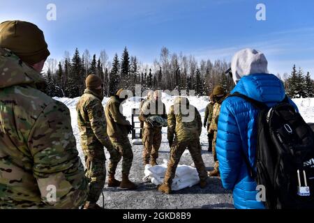 US Air Force-Piloten des 354. Civil Engineer Squadron Explosive Ordnance Disposal (EOD)-Fluges und das Team von Iceman Spark Innovation positionieren Taschen für ein Schneemilderungsexperiment am 18. März 2021 auf der Eielson Air Force Base, Alaska. Iceman Spark, EOD, Junior Force Warfighter Operations Team, das Innovationsteam des Air Force Research Laboratory und andere Partner haben sich zusammengeschlossen, um das Schneeminderungsexperiment zu entwickeln. Stockfoto