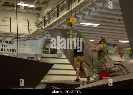 210318-M-UY835-1002 ARABIAN SEA (18. März 2021) – Brent ward, Left, und Zachary Sheffield, beide F-35B Lightning II Mechaniker mit dem F-35 Rapid Response Team, Fleet Readiness Center East bringen ein Gurtzeug an, um einen Schwanz aus einem Flugzeug an Bord des amphibischen Angriffsschiffs USS Makin Island (LHD 8), März 18, zu entfernen. Die Makin Island Amphibious Ready Group und die 15. Marine Expeditionary Unit werden in das Einsatzgebiet der 5. US-Flotte eingesetzt, um Marineinteroperationen zu unterstützen, um die maritime Stabilität und Sicherheit in der zentralen Region zu gewährleisten und das Mittelmeer und den Pazifik durch den Westen zu verbinden Stockfoto