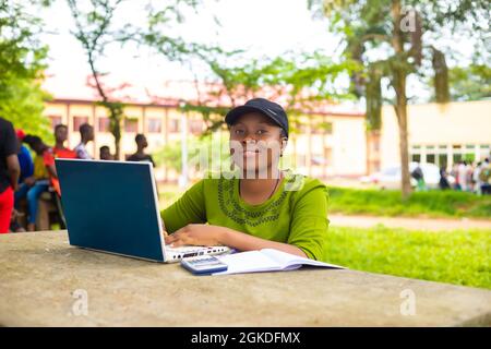 Eine hübsche afrikanische Frau studiert auf dem Schulcampus Stockfoto