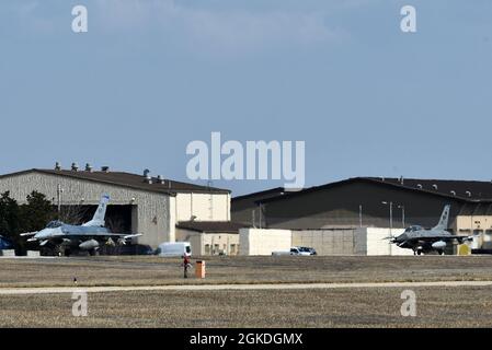 Zwei F-16-Kampffalken aus dem 35. Jagdgeschwader „Juvats“-Taxi auf der Fluglinie auf dem Kunstan Air Base, Republik Korea, 22. März 2021. Die F-16 Fighting Falcon ist ein kompaktes, multifunktioniges Kampfflugzeug, das sich in Luft-Luft-Kämpfen und Luft-zu-Boden-Angriffen sehr gut manövrieren lässt. Stockfoto