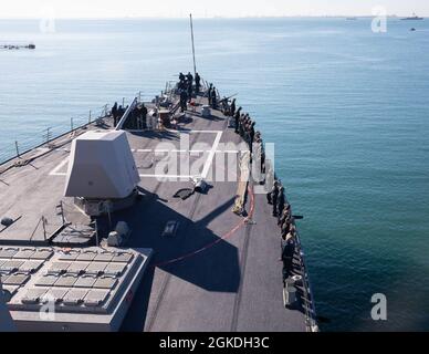 210322-N-CJ510-0041 MARINESTATION ROTA, Spanien (22. März 2021) Seeleute an Bord des Arleigh Burke-Klasse-Lenkrakenzerstörers USS Roosevelt (DDG 80) fahren während einer See- und Ankerentwicklung am 22. März 2021 auf die Schienen. Roosevelt, der im spanischen Rota stationiert ist, bereitet sich auf seine zweite Patrouille im Einsatzgebiet der Sechsten US-Flotte vor, um regionale Verbündete und Partner sowie nationale Sicherheitsinteressen der USA in Europa und Afrika zu unterstützen. Stockfoto