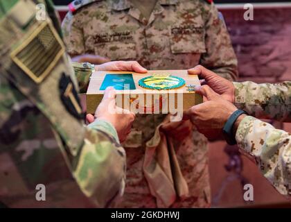 Der spartanische Kommandant der Task Force, Maj. General Patrick Hamilton, wurde als Zeichen der Anerkennung für seine Gastrednerin bei einer hochrangigen Führungspersönlichkeit der Kuwait-Landstreitkräfte in der Nähe von Kuwait City am 22. März 2021 überreicht. Hamilton wurde gebeten, Gastredner zu sein und Erfahrungen und Erfahrungen aus der Vergangenheit über die strategische Vermittlung der militärischen Mission innerhalb der Organisation an die Partnerländer und die Öffentlichkeit auszutauschen. Stockfoto