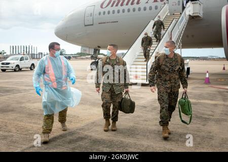 Australian Army Warrant Officer Class 2 Lee Pendlebury, links, ein Operationsbefehl-Offizier bei Marine Rotational Force – Darwin, begrüßt US Marine Corps Col. David Banning, Center, Kommandant von MRF-D, und Sgt. Maj. William Harrington, Hauptfeldwebel von MRF-D, als sie in Darwin, Royal Australian Air Force Base, Darwin, NT, Australien, im März 22 eintreffen, 2021. Marineinfanteristen und Seeleute mit MRF-D sind verpflichtet, vor ihrer Ankunft in Darwin strenge COVID-19-Minderungsverfahren gemäß den Gesundheitsbehörden des Northern Territory durchzuführen. Alle Service-Mitglieder müssen drei dokumentierte n bereitstellen Stockfoto