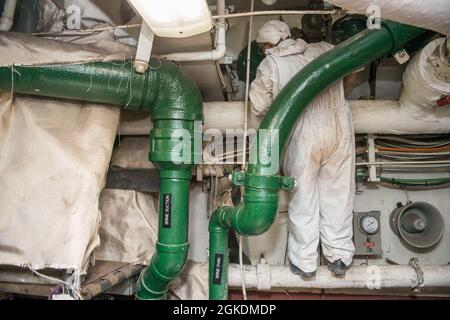 210323-N-EI510-0018 GAETA, Italien (23. März 2021) ein italienischer Auftragnehmer hilft bei der Reparatur an Bord des Kommandoschiffs USS Mount Whitney (LCC 20) der Blue Ridge-Klasse in Gaeta, Italien, am 23. März 2021. Mount Whitney, der nach Gaeta, Italien, entsandt wird, arbeitet mit einer kombinierten Besatzung von Matrosen und Militärsealift Command-Seeleuten im Einsatzgebiet der Sechsten Flotte der USA zur Unterstützung der nationalen Sicherheitsinteressen der USA in Europa und Afrika. Stockfoto