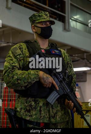 210323-N-SY758-1017 PORTSMOUTH, VA. (23. März 2021) Aviation Boatswain Mate (Fuel) 3rd Class Brian Rosa aus Camden, New Jersey, steht an Bord des Flugzeugträgers USS George H. W. Bush (CVN 77) eine bewaffnete Quarterdeck-Uhr. GHWB befindet sich derzeit in der Norfolk Naval Shipyard wegen der geplanten Andockbarkeit. Stockfoto