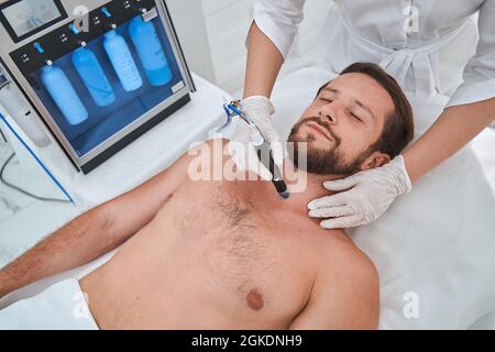 Männlicher Patient, der sich der Hautfeuchtigkeitspflege unterziehen muss Stockfoto