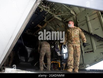 Ein Airman lädt Fracht auf einen HC-130J Combat King II am Springfield-Beckley Municipal Airport, Ohio, 23. März 2021. Die Ladung war ein ELEKTRONISCHES vertikales Start- und Landeflugzeug, das das 79. Rettungsgeschwader von Ohio nach Texas transportierte. Diese Transportbemühungen dienten als Proof of Concept, da der 355. Flügel plant, eVTOL in bevorstehende Übungen zu integrieren, um seine agilen Kampfarbeitsfähigkeiten zu fördern. Stockfoto