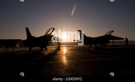 Zwei 120. Jagdgeschwader F-16 Fighting Falcons vom Luftwaffenstützpunkt Buckley, Colorado, sitzen während der Übung Amalgam Dart 21-02, 22. März 2021, auf dem Fluglinevorfeld des Luftwaffenstützpunktes Thule, Grönland. Die Übung wird vom 20-26. März an durchgeführt und reicht von der Beaufort-See bis nach Thule, Grönland, und erstreckt sich südlich des Ostatlantiks bis zur US-Küste von Maine. Amalgam Dart 21-02 bietet NORAD die Möglichkeit, die Fähigkeiten der Heimatverteidigung zu verbessern, da kanadische, US- und NATO-Streitkräfte in der Arktis zusammenarbeiten. NORAD ist ein binationales kanadisches und amerikanisches Kommando und setzt auf Netzwerk-Weltraumbasis, Luftaufnahmen und gro Stockfoto