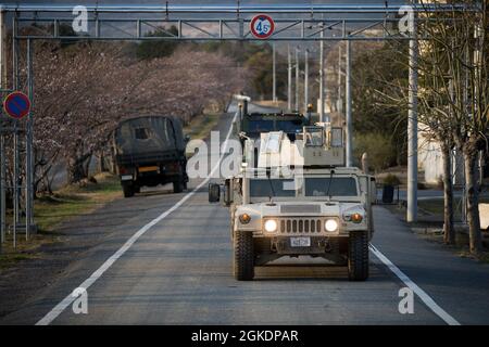 US Marine Corps Humvees und 7-Tonnen-Lastwagen mit Marine Wing Support Squadron (MWSS) 171 treffen am 23. März 2021 im japanischen Selbstverteidigungslager Nihonbara ein. Marineinfanteristen mit MWSS-171 nehmen an einer zweiwöchigen Feldübung Teil, um ihre Fähigkeiten beim Aufbau einer Vorwärtsoperationsbasis, eines Vorwärts-Bewaffnungs- und Betankungspunkts sowie bei der Durchführung von Live-Feuerereignissen zu verbessern. Stockfoto