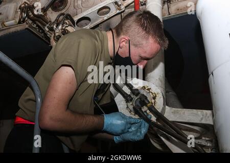 Senior Airman Brandon Adams, 7th Equipment Maintenance Squadron Repair and Rekultivation Journeyman, installiert Zerk-Armaturen, um die Stifte im Hauptfahrwerk des Lancer B-1B auf der Dyess Air Force Base, Texas, zu schmieren, 24. März 2021. Die 7th EMS Airmen warten und liefern Bodenausrüstung für die Luft- und Raumfahrt, fertigen und installieren Komponenten, führen zeitphasige Flugzeuginspektionen rechtzeitig durch sowie die Wartung von abgestürzten, beschädigten oder behinderten Flugzeugen. Stockfoto