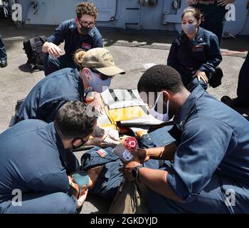 Seemann an Bord des Arleigh Burke-Klasse Lenkraketen-Zerstörers USS Benfold (DDG 65) leistet medizinische Hilfe für ein Besatzungsmitglied während einer medizinischen Trainingsübung. Benfold ist der Task Force 71/Destroyer Squadron (DESRON) 15 zugeordnet, der größten vorwärtseingesetzten DESRON der Marine und der wichtigsten Surface Force der 7. US-Flotte Stockfoto