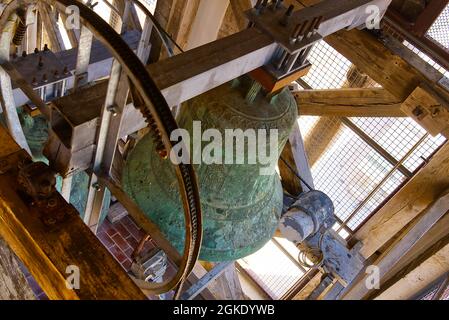 Mittelalterliche traditionelle alte Glocken in einem Kirchturm. Glocke und Montagekonstruktion. Blick auf eine Glocke auf dem Turm Stockfoto