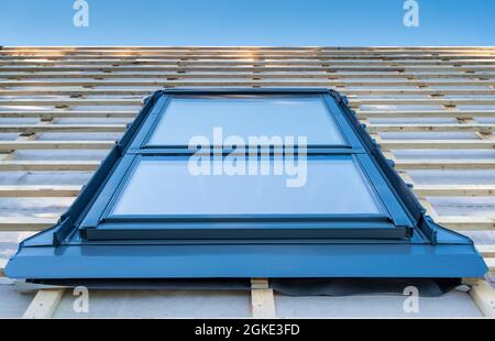 Installation eines neuen Fensters auf dem Dach eines Privathauses. Stockfoto