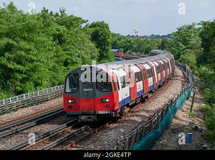 Ein Zug der Jubilee Line in Richtung Norden von Elephant und Castle nach Stanmore am Ufer nördlich von Queensbury, mit einem abfahrenden Zug in der Ferne Stockfoto