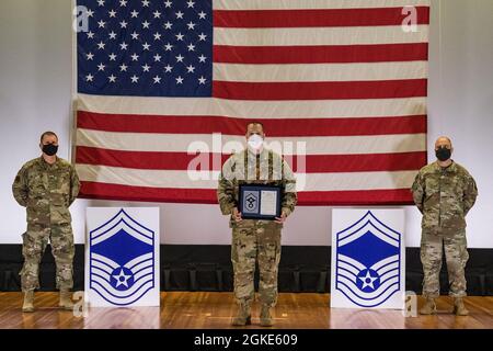 Master-Sgt. Christopher Lopardi, 436. Stellvertretender Leiter der Ausbildung des Bauingenieurgeschwaders, steht zwischen Col. Matthew Jones, 436. Kommandant des Luftlift-Flügels, links, und Chief Master Sgt. Jeremiah Grisham, der 436. Interim-Kommandochef der AW, posiert für ein Foto während der Zeremonie zur Freigabe des Senior Master Sergeant, die am 26. März 2021 im Basistheater auf der Dover Air Force Base, Delaware, stattfand. Lopardi war einer von 10 Master-Sergeanten auf der AFB Dover, die für die Beförderung zum Senior Master-Sergeant im Promotionszyklus 21E8 ausgewählt wurden. Stockfoto