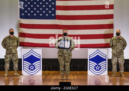 Master-Sgt. Marilyn Landers, Leiter der Abteilung für individuelle Schutzausrüstungen der 436. Logistics Readiness Squadron, steht zwischen Col. Matthew Jones, dem 436. Kommandanten der Luftbrücke, links, und Chief Master Sgt. Jeremiah Grisham, der 436. Interim-Kommandochef der AW, posiert für ein Foto während der Zeremonie zur Freigabe des Senior Master Sergeant, die am 26. März 2021 im Basistheater auf der Dover Air Force Base, Delaware, stattfand. Landers war einer von 10 Master-Sergeanten auf der AFB Dover, die für die Beförderung zum Senior Master-Sergeant im Förderzyklus 21E8 ausgewählt wurden. Stockfoto