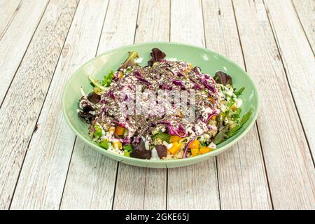 Maissalat mit Joghurt sind Weizensamen und Lila-Kohl auf einem grünen tiefen Teller Stockfoto