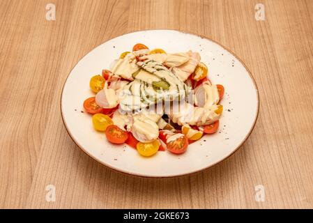 Salat mit Kirschtomaten, normalen Tomaten, eingelegten Gurken, Thunfischbauch und eingelegtem Schnittlauch Stockfoto