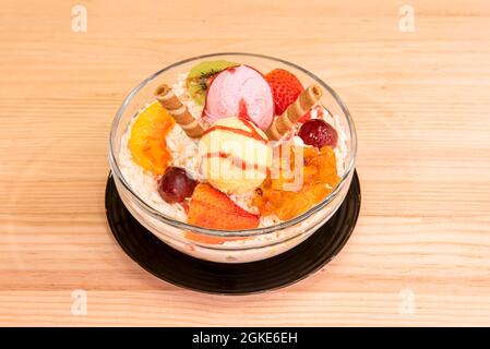 Obstsalat und Eis mit Käse, roten Trauben, reifen Erdbeeren, Kiwi und Kekswaffeln. Stockfoto