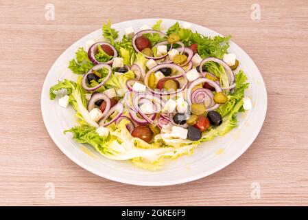 Griechischer Salat mit schwarzen Oliven, Kirschtomaten, Escarole, roten Zwiebeln und eingelegten Gurken Stockfoto