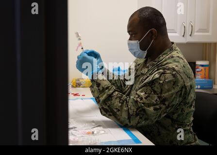 U.S. Navy LT. Cmdr. Ebenezer Aniagyei, ein Sicklerville, New Jersey, gebürtiger Einheimischer und Apotheker, der dem Naval Medicine Readiness Training Center New England zugewiesen ist, bereitet einen Impfstoff im staatlich geführten, föderal unterstützten First Baptist Church of Lincoln Gardens COVID-19 Community Vaccine Center in Somerset, New Jersey, 26. März 2021. Dieses Zentrum impft derzeit Gemeindemitglieder, die ihre zweite Dosis des COVID-19-Impfstoffs erhalten sollen. Das U.S. Northern Command setzt sich über die U.S. Army North weiterhin dafür ein, dem Federal Emergency man weiterhin flexible Unterstützung durch das Verteidigungsministerium zu bieten Stockfoto