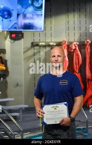 Navy-Tauchlehrer 1. Klasse Ryan M. Murphy wurde am 26. März 2021 von Captain Steven W. Antcliff, Kommandant der Naval Submarine School, an Bord der Naval Submarine Base New London, als Instruktor des Viertels für das zweite Quartal 2021 anerkannt. Als PSET-Kontrollbeamter lieferte Murphy fachmännisch 86 Stunden Unterricht, um die erfolgreiche Graduierung von über 470 Studenten in diesem Quartal sicherzustellen. Murphy wurde auch nicht nur als hervorragender Lehrer für die Schüler der Naval Submarine School anerkannt, sondern auch als Mentor für seine Kollegen in der Hochrisikoabteilung. Stockfoto