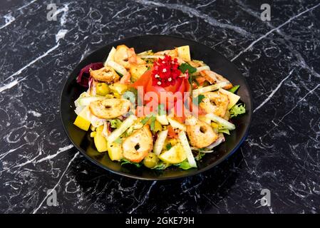 Schwarzer Teller mit indischem bangalore-Salat mit gegrilltem Hähnchen, Obst und Gemüse Stockfoto