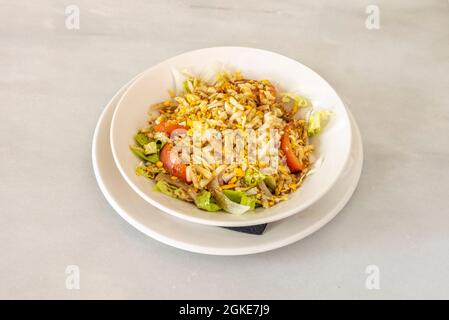 Gemischter, nicht sehr auffälliger Salat mit Tomatenstücken, Zwiebeln, Salat und fein gehackten, hart gekochten Eiern Stockfoto