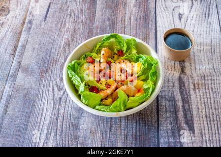 Salat mit thailändischem Rezept aus gekochten Garnelen mit Ananas und Mango, rotem Pfeffer und Tomaten, Sojasauce und Sesam und Mohn Stockfoto