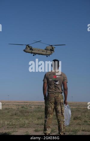 US-Soldaten mit der 28. Expeditionary Combat Aviation Brigade säubern Fremdkörper während eines FOD-Spaziergangs auf einem Flugplatz im Einsatzgebiet des 28. ECAB im Nahen Osten. FOD, einschließlich Müll, Felsen oder Fahrzeugteile, kann einen Hubschrauber schwer beschädigen, daher sind diese FOD-Wanderungen wichtig, um unsere Flugzeugbesatzungen sicher zu halten. Stockfoto