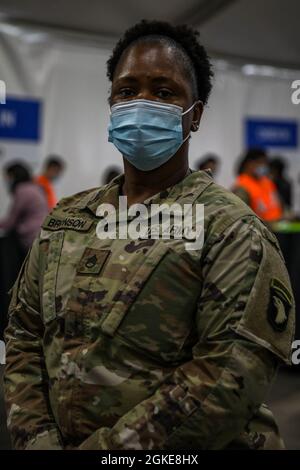 US Army Staff Sgt. Jackie Bronson, eine in Mount Harmon, Louisiana, geborene und Wasseraufbereitungsspezialistin bei Alpha Company, 426. Brigade Support Bataillon, 1. Brigade Combat Team, 101. Airborne Division (Air Assault), posiert für ein Foto während ihrer Pause im United Center Community Vaccination Center, Chicago, 27. März 2021. Bronsons Hauptaufgabe ist es, den Strom von Gemeindemitgliedern zu kontrollieren, die bei der Registrierung und auf dem Weg zur Impflinie durch die Linie kommen. „Ich denke, dass wir alle etwas bewirken“, sagte Bronson. „die Patienten sind sehr positiv und jeder sagt immer das vacc Stockfoto