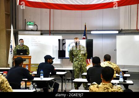 210328-G-DV874-0032 MARINESTÜTZUNGSAKTIVITÄT BAHRAIN (28. März 2021) – US Coast Guard LT. j.g. Miles Miller diskutiert die Boarding-Verfahren der US-Küstenwache mit Mitgliedern der Royal Bahrain Naval Forces und der Bahrain Coast Guard im Rahmen eines fachlichen Expertenaustauschs zur Vorbereitung der Übung Neon Defender 21 an Bord der Naval Support Activity Bahrain, März 28. Neon Defender 21 ist ein bilaterales Seeverkehrsmanöver zwischen den USA und Bahrain, das darauf ausgelegt ist, die Interoperabilität und Bereitschaft zu verbessern, die Beziehungen zwischen Militär und Militär zu stärken und die operativen Fähigkeiten zu verbessern und eine Teilnahme zu ermöglichen Stockfoto