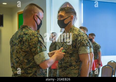 U.S. Marine Corps Maj. General James Bierman, Kommandierender General der 3d Marine Division, überreicht eine Medaille für die Leistungen der Marine und des Marine Corps an die U.S. Marine Corps Lance CPL. Austin Rednerhlavacek, ein Randalier mit 3d-Bataillon, 8th Marines, 3d Marine Division in Camp Schwab, Okinawa, Japan, 29. März 2021. Rednerhlavaceks Mannschaft war der Gewinner des 3d Marine Division Rifle Squad Competition. Das Ereignis testete die Überlebensfähigkeiten des Dschungels, grundlegende Infanterietaktiken und hervorragende Waffenverarbeitung. 3/8 ist derzeit als Teil des Unit Deployment Program an das 4. Marine Regiment angeschlossen. Stockfoto