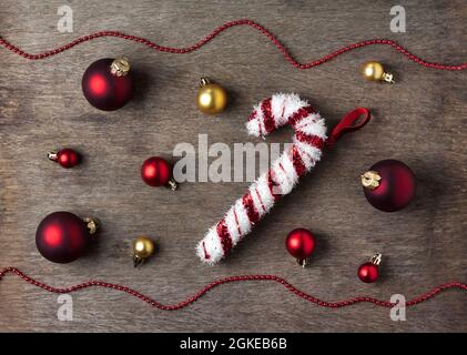 Weihnachtskomposition mit roten und goldenen Weihnachtskugeln, Schneeflocken und Süßigkeitenspielzeug auf Holzhintergrund. Weihnachten, Neujahr Konzept. Flache Lay, Stockfoto