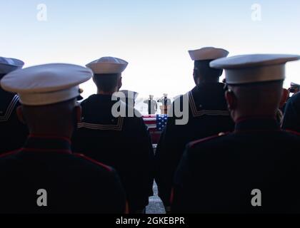 PAZIFISCHER OZEAN (29. März 2021) Seeleute und Marineinfanteristen nehmen an einer Beerdigung auf See an Bord des amphibischen Sturmschiffs USS Essex der Wasp-Klasse (LHD 2) Teil. Essex führt derzeit Routineoperationen in der dritten US-Flotte durch. Stockfoto