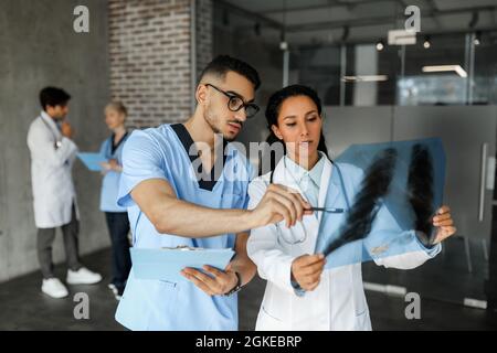 Zwei junge Ärzte betrachten Röntgenaufnahmen Stockfoto