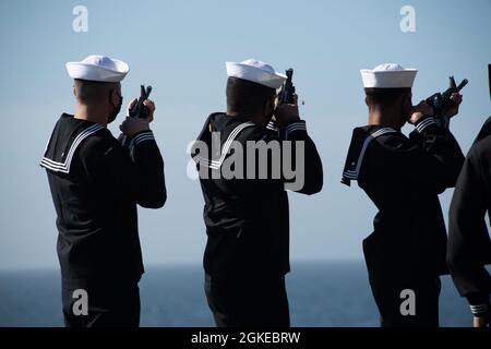 PAZIFISCHER OZEAN (29. März 2021) Seeleute grüßen während einer Beerdigung auf See an Bord des amphibischen Sturmschiffs USS Essex der Wasp-Klasse (LHD 2). Essex führt derzeit Routineoperationen in der dritten US-Flotte durch. Stockfoto