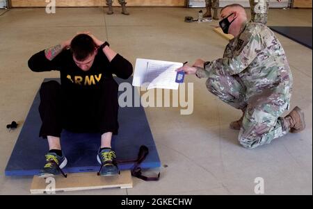 Ein Soldat der Nationalgarde der Armee von Michigan führt Sit-Ups während eines körperlichen Fitness-Tests der Armee durch, der im Rahmen des Best Warrior Competition stattfand, der vom 28. Bis 31. März 2021 im Fort Custer Training Center in Augusta, Michigan, stattfand. Im Wettbewerb „Beste Krieger“ treten Soldaten und nicht beauftragte Offiziere aus dem ganzen Staat gegeneinander an, um zu sehen, wer die beste Gesamtbeherrschung ihrer Soldatenfähigkeiten besitzt. Stockfoto