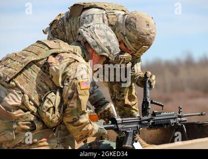 Soldaten mit Bush Master Company, 2. Bataillon, 22. Infanterie-Regiment, 1. Brigade-Kampfteam, 10. Bergdivision (LI), verwenden am 30. März 2021 in Fort Drum, N.Y., während des M249-Eingewöhnungstrainings eine Schmierung für einen M249. Die Schmierung verhindert Fehlfunktionen der Waffe, die während einer Kampfsituation schädlich sein könnten. Stockfoto