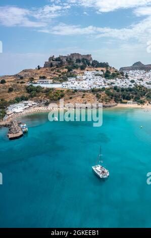 Segelboot auf türkisfarbenem Meer, Sandstrand, Akropolis von Lindos, alte Zitadelle auf einer steilen Klippe, Lindos, Rhodos, Dodekanes, Griechenland Stockfoto