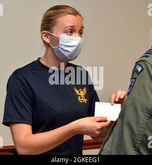 JACKSONVILLE, Florida (30. März 2021) - Valerie Erlenbusch, 2. Klasse des Hospital Corpsman, übergibt einem Matrosen an der Impfstelle COVID-19 des Naval Hospital Jacksonville eine Impfkarte. Erlenbusch, ein gebürtiger Kolumbus, Ohio, sagt: „Impfungen ermöglichen es einer größeren Bevölkerung, sicher zu sein, und ich möchte alles tun, was ich kann, um zu helfen.“ Die Woche der öffentlichen Gesundheit findet vom 5. Bis 11. April statt, in der die Beiträge der öffentlichen Gesundheit zur Verbesserung der Gesundheit und Sicherheit unseres Landes hervorgehoben werden. Stockfoto