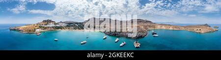 Segelboote ankern vor Lindos, türkisfarbenes Meer, Sandstrand, Akropolis von Lindos, alte Zitadelle auf einer steilen Klippe, Lindos, Rhodos Stockfoto