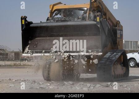 Flugkörper, die dem 386. Expeditionary Civil Engineer Squadron zugewiesen sind, bedienen schwere Maschinen, um Trümmer auf einem replizierten Flugplatz während einer Raw Airfield Damage Recovery (RADR)-Übung auf der Ali Al Salem Air Base, Kuwait, 31. März 2021, zu beseitigen. RADR ist ein Konzept, das es CE-Mitarbeitern ermöglicht, auf einer beschädigten Landebahn nach einem Angriff eine minimale Flugplatzbetriebsfläche zu entwickeln und diese zu reparieren, um die Mission fortzusetzen. Stockfoto