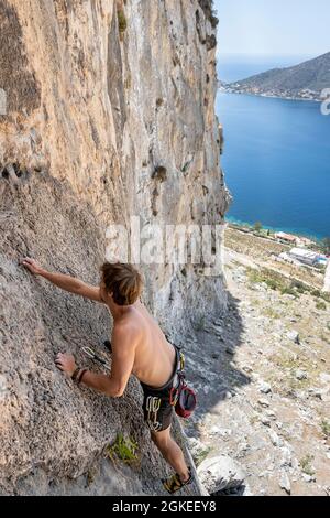 Junger Mann, der auf einer Felswand klettert, Bleibergsteiger, Sportkletterer, Kalymnos, Dodekanes, Griechenland Stockfoto