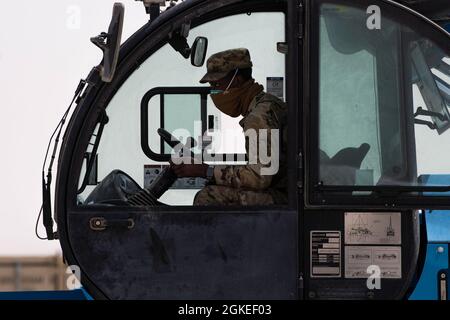 Ein US-Luftwaffenflieger, der dem 386. Expeditionary Civil Engineer Squadron zugewiesen wurde, betreibt einen Teleskoplader, der mit Beton gefüllte Säcke während einer Raw-Übung (RADR) auf der Ali Al Salem Air Base, Kuwait, 31. März 2021, hebt. Wenn ein Flugplatz beschädigt wird, können diese Airmen den Flugplatz wieder in Funktion bringen, indem sie Felduntersuchungen durchführen, ihre notwendige Ausrüstung sammeln und sich auf die Reparatur der verursachten Schäden wagen, um die Einsatzbereitschaft zu gewährleisten. Stockfoto