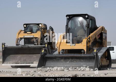 Flugkörper, die dem 386. Expeditionary Civil Engineer Squadron zugewiesen sind, bedienen schwere Maschinen, um Trümmer auf einem replizierten Flugplatz während einer Raw Airfield Damage Recovery (RADR)-Übung auf der Ali Al Salem Air Base, Kuwait, 31. März 2021, zu beseitigen. RADR ist ein Konzept, das es CE-Mitarbeitern ermöglicht, auf einer beschädigten Landebahn nach einem Angriff eine minimale Flugplatzbetriebsfläche zu entwickeln und diese zu reparieren, um die Mission fortzusetzen. Stockfoto