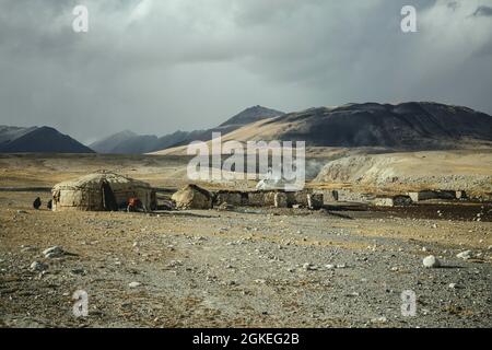 Steinjurten und Ställe, kirgisische Nomadensiedlung, Bozai Gumbaz, im Hintergrund das Pamir-Gebirge und die Grenze zu Tadschikistan, Wakhan Stockfoto