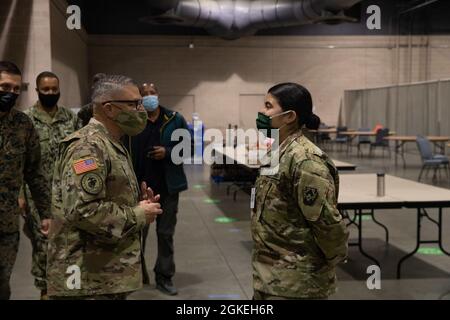 General Jeff Van, links der US-Armee, kommandierender General der Joint Task Force Civil Support, Joint Base Langley-Eustis, lobt die Pennsylvania Army National Guard Sgt. Sophia Amaya, rechts, gebürtige Philadelphia und Generatormechanikerin bei der 252. Quartermaster Company, 728. Combat Sustainment Support Bataillon, während einer Tour durch das staatlich geführte, föderal unterstützte Center City Community Vaccination Center im Pennsylvania Convention Center in Philadelphia, 31. März 2021. Armee- und Luftwaffenschützer mit der Pennsylvania National Guard werden zur Unterstützung der föderalen Impfreaktion eingesetzt Stockfoto