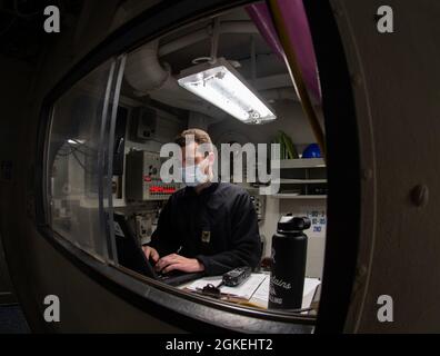 210331-N-LZ409-1089 PORTSMOUTH, VA. (31. März 2021) Yeoman 2nd Class Nicholson aus Tampa, Florida, nimmt an Bord des Flugzeugträgers USS George H. W. Bush (CVN 77) einen Eintrag in das Deckbuch vor. GHWB befindet sich derzeit in der Norfolk Naval Shipyard wegen der geplanten Andockbarkeit. Stockfoto